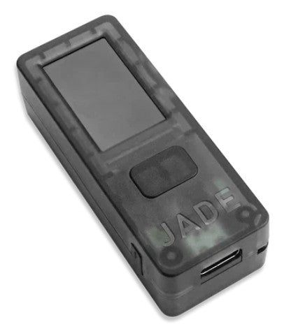 The Blockstream Jade is a compact, rectangular black electronic device with a clear screen and a single button beneath it. The word "JADE" is embossed on the lower right corner, and its slightly transparent casing reveals the internal components engineered for secure Bitcoin storage. It includes a USB port on the side to facilitate easy access.