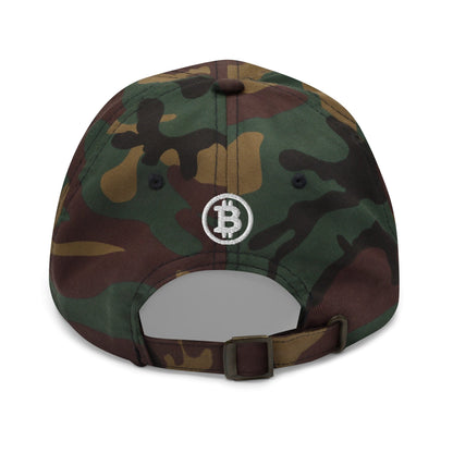 A rear view of the Hashtag hat showcases a green, brown, and black camouflage pattern inspired by Australia's rugged landscapes. The cap prominently displays an embroidered Bitcoin logo in white thread at its center. It is adjustable with a metal buckle strap.