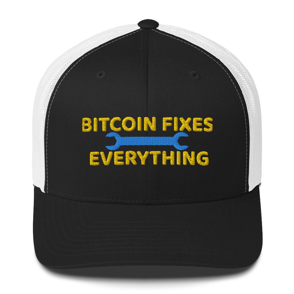 A black and white UTXO Dreams trucker hat with the text "Bitcoin Fixes Everything" embroidered in yellow and blue, emphasizing cryptocurrency's impact.