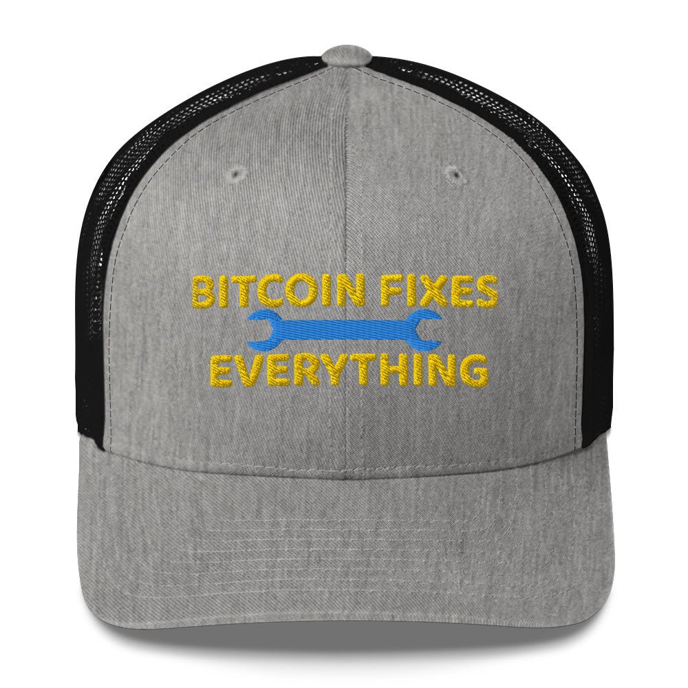 A gray and black UTXO Dreams trucker hat with the phrase "Bitcoin Fixes Everything" embroidered on the front, featuring Bitcoin's symbolic "b" with two vertical lines through it.