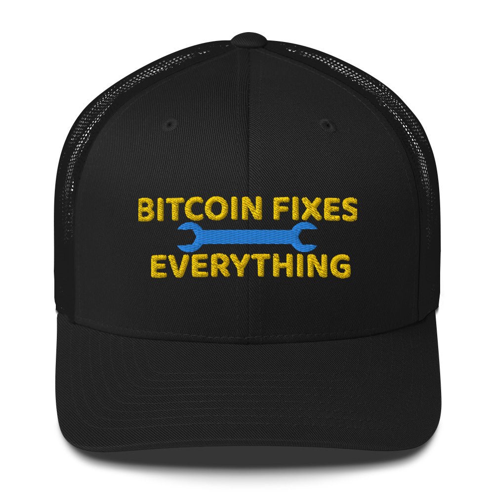 A black Bitcoin Fixes Everything Trucker Cap with a mesh back featuring the slogan "Bitcoin Fixes Everything" in bold yellow letters, with a blue wrench graphic on both sides of the text, representing the idea that bitcoin offers by UTXO Dreams.